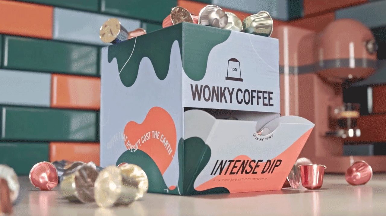 Product animation still of a coffee capsule box design, coffee capsules scattered on a kitchen counter